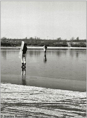 Carrying Roseman's newly painted canvases, Davis (foreground) and Anderson cross a frozen stretch of the Cábardasjohka River. Kautokeino, 1976. Photo © Stanley Roseman